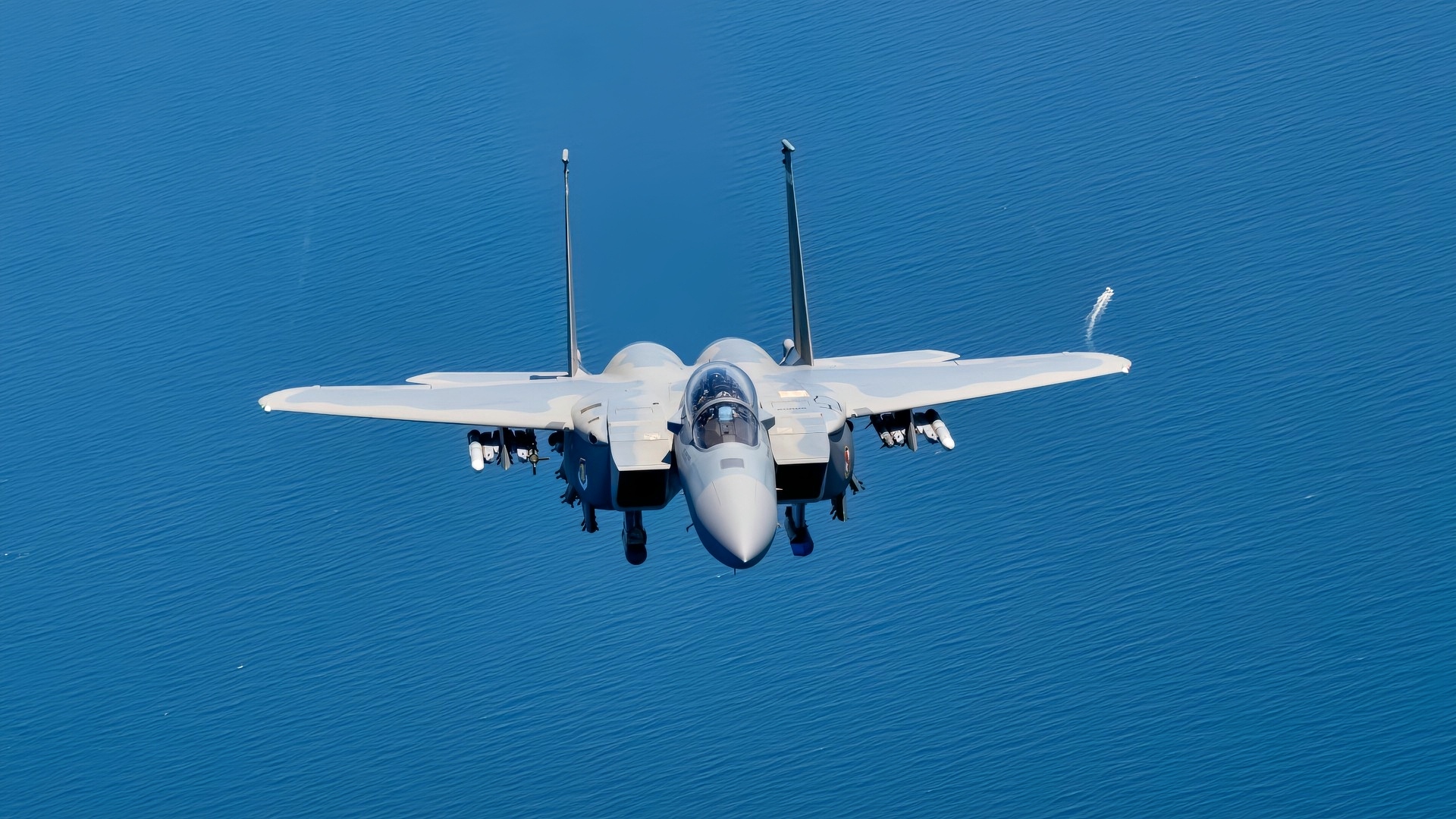 A U.S. Air Force F-15EX Eagle II flies over open water.